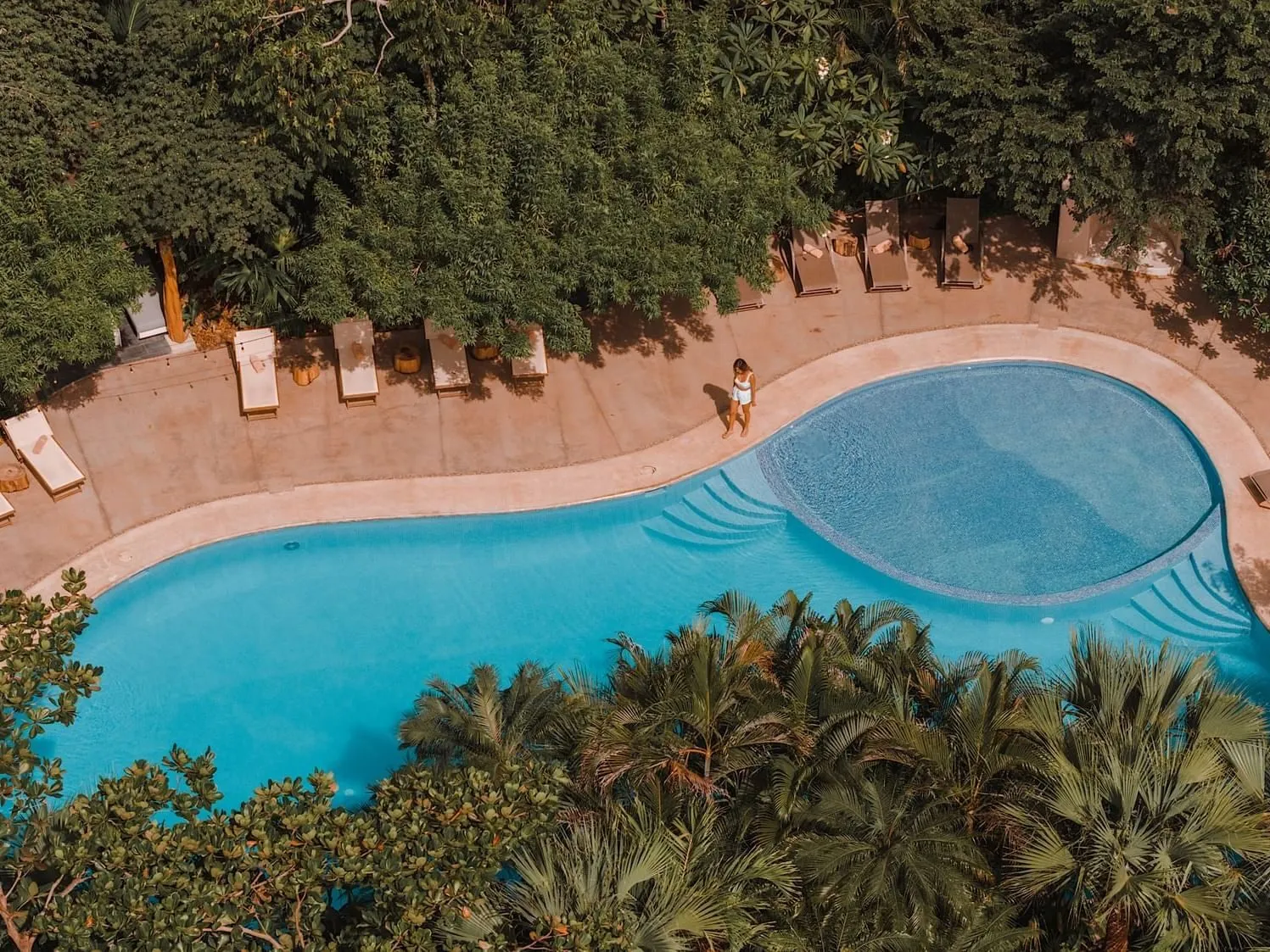Loungers beside the curved pool at Cala Luna in Playa Langosta